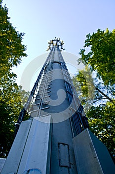 3G, 4G, LTE Telecommunication mast and green trees at the blue sky