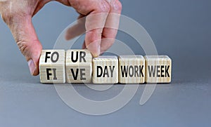 4 or 5 day work week symbol. Businessman turns cubes, changes words `five day work week` to `four day work week`. Beautiful gr