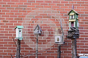 4 birdhouses with brick background