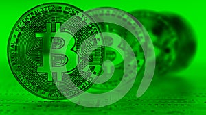 4 Bitcoins with focus on front coin in a green tint