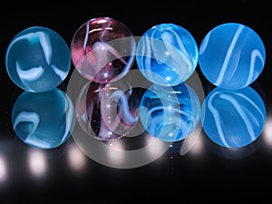 4 colourful glass marbles with a dark background