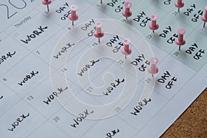 4 day work week printed calendar with pink pins on three days off in week weekend days four day working week concept