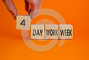 4 day work week symbol. Businessman holds the cube with words `4 day work week`. Beautiful orange background. Copy space. Busine