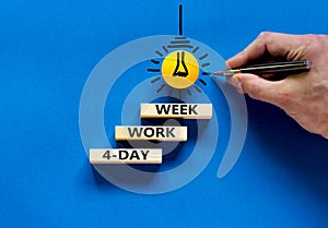 4-day work week symbol. Concept words 4-day work week on wooden blocks on beautiful blue table blue background. Businessman hand.