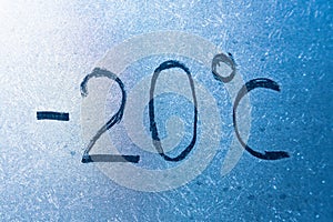 -4 degrees Fahrenheit or -20 Celsius number lettering on icy glass covered with ice and frost. The concept of extreme cold weather