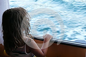 4 and a half year old girl looks at the view of the bay of Igoumenitsa from the window