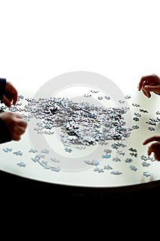 4 hands doing a puzzle