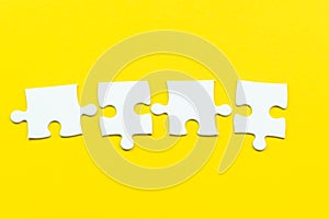 4 jigsaw puzzle on solid yellow background using as 4 important thing combine or working together to success or solve problem