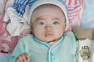 4 Month Asian Chinese baby boy suffering high fever with wet towel on his forehead to relief the temperature
