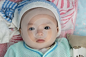 4 Month Asian Chinese baby boy suffering high fever with wet towel on his forehead to relief the temperature