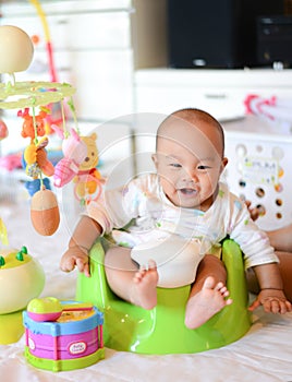 4 Month old Asian baby sitting on baby floor seat