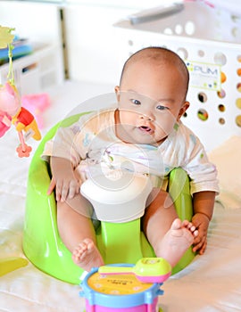 4 Month old Asian baby sitting on baby floor seat