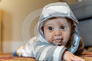 A 4 month old baby wears a sweatshirt with a hoodie