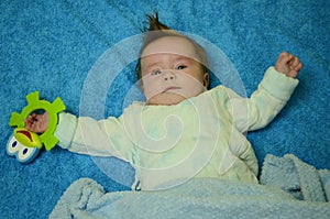 4 month old boy with frog toy on blue backgraund