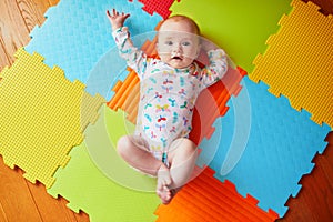 4 months old baby girl lying on colorful play mat
