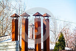 4 old rusted smoke chimneys on a roof