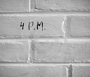 4 P.M. WRITTEN ON WHITE PLAIN BRICK WALL