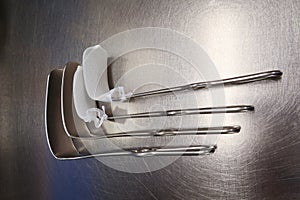 4 surgical abdominal retractors lie on a silver base