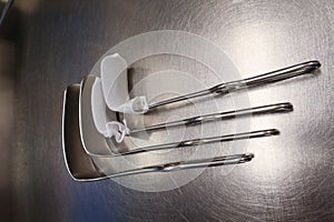 4 surgical abdominal retractors lie on a silver base