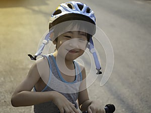 A 4-year-old Asian boy smiled happily with the opportunity to exercise by riding a scooter