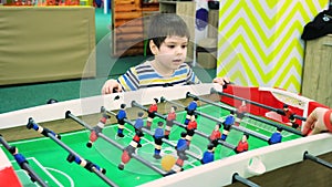 A 4-year-old boy plays table football in the children's playroom.