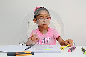 4-year-old brunette Latina girl with autism spectrum disorder ASD like Asperger, Rett and Heller draws at a desk, plays with color