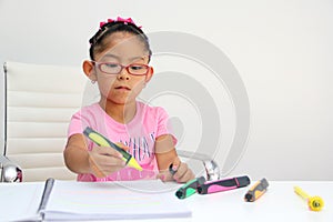 4-year-old brunette Latina girl with autism spectrum disorder ASD like Asperger, Rett and Heller draws at a desk, plays with color