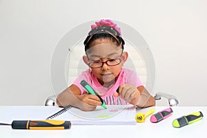 4-year-old brunette Latina girl with autism spectrum disorder ASD like Asperger, Rett and Heller draws at a desk, plays with color