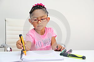 4-year-old brunette Latina girl with autism spectrum disorder ASD like Asperger, Rett and Heller draws at a desk, plays with color