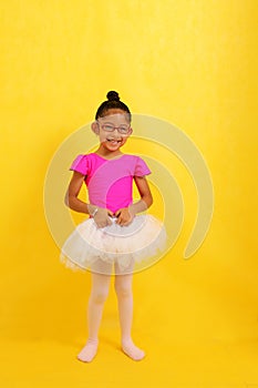 4 year old brunette Latina girl in a leotard and tutu takes her ballet class to improve her posture, flexibility and circulation