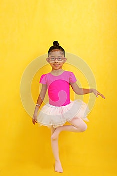 4 year old brunette Latina girl in a leotard and tutu takes her ballet class to improve her posture, flexibility and circulation