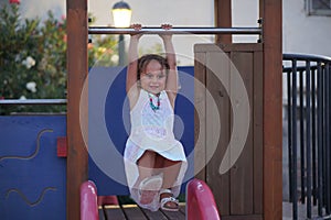 a 4 year old girl plays alone in a children's playground in Finikounda