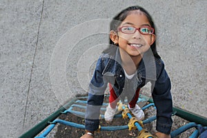 4-year-old Latin brunette girl plays in a playground, does physical activity as ADHD therapy, living in poverty