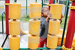 4 year old Latina brunette girl with eye glasses plays in the park games in poverty spends her vacation days with autism