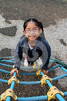 4 year old Latina brunette girl with eye glasses plays in the park games in poverty spends her vacation days with autism