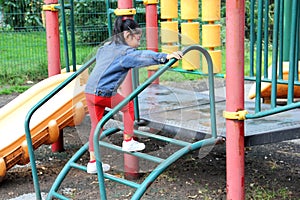 4 year old Latina brunette girl plays in the playground as therapy for Attention Deficit Hyperactivity Disorder ADHD