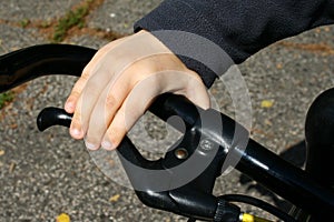 4 years old boy hand on black bicycle grip-brake