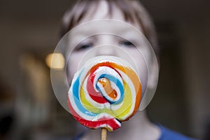 4 years old child boy wtih a colorful big lollipop