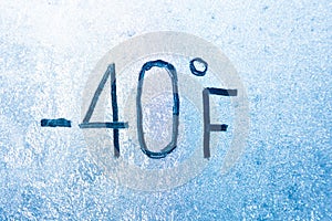 -40 degrees Fahrenheit or 0 Celsius number lettering on icy glass covered with ice and frost. The concept of extreme cold weather