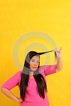 40-year-old Latina woman with long hair suffers from having it mistreated, observes her damaged split ends that need treatment