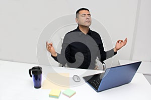 40-year-old Latino man breathes pranayama and practices yoga to relax and de-stress from work pressure and prevent burnout