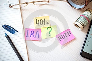 401k ira roth on pieces of colorful paper dollars on table. Pension concept. Retirement plans