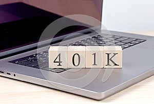 401K word on wooden block on laptop, business concept