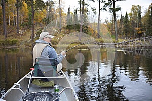 40s caucasian fisherman fishing on small lake in northern Minnesota during fall
