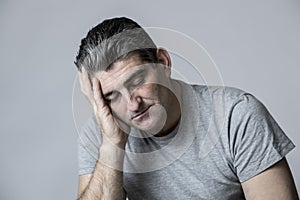 40s to 50s sad and worried man looking frustrated and thoughtful in worried and pensive face expression isolated on grey