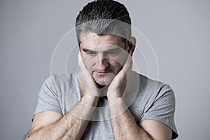 40s to 50s sad and worried man looking frustrated and thoughtful in worried and pensive face expression isolated on grey