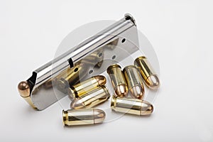 .45 ACP bullets and gun magazine on white background