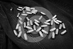 .45 ACP cartridges on a black denim background, monochrome photo