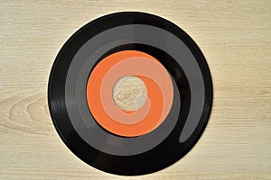 45 rpm old vinyl record on the wooden table