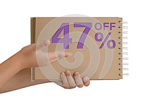 47 percent discount on isolate. Notepad from recycled paper in the hands of a child with text, sale up to 47 percent